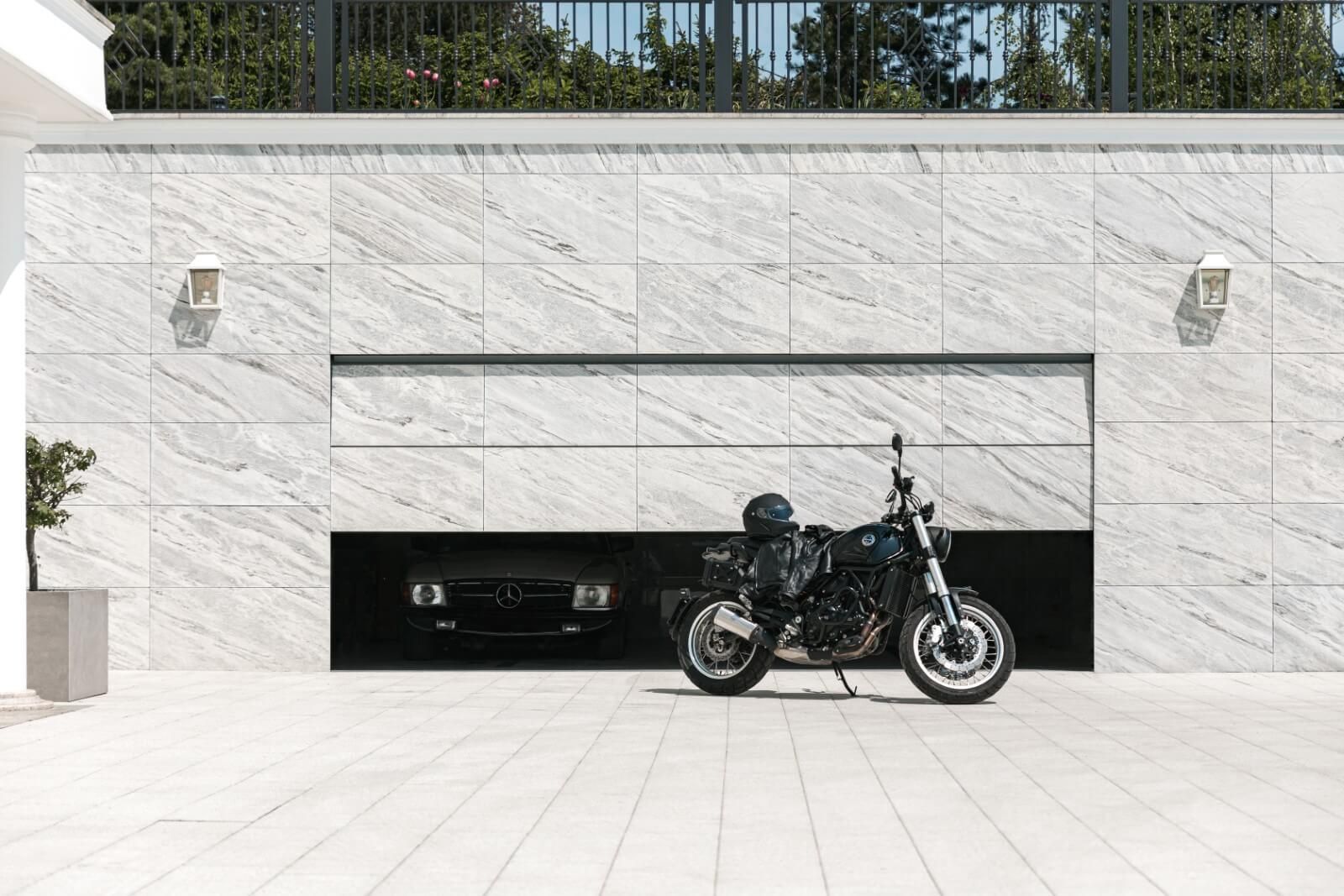 Porta da garage a filo con la facciata in pietra